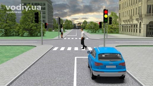 Синій автомобіль перед перехрестям, червоний і жовтий сигнали світлофора, пішохід на пішохідному переході.
