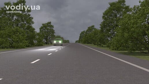 Автомобіль з увімкненими фарами на дорозі поза населеним пунктом у темну пору доби. Що вважається темною порою доби згідно з ПДР.