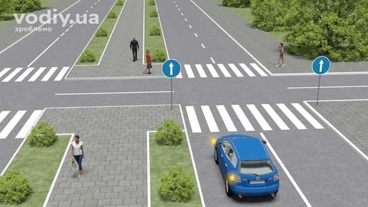 Синій автомобіль перед перехрестям з увімкненим покажчиком повороту, дорожній знак 4.1 «Рух прямо», пішоходи на тротуарі та пішохідному переході.