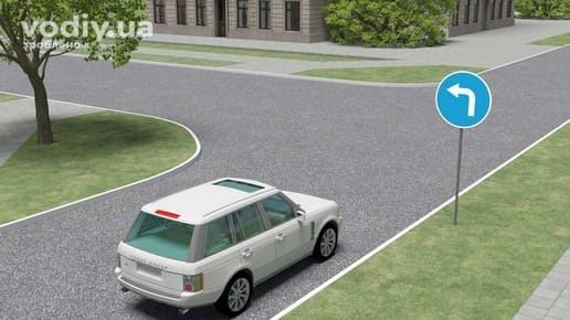Білий позашляховик перед Т-подібним перехрестям, дорожній знак 4.3 «Рух ліворуч», край проїзної частини з бордюром.
