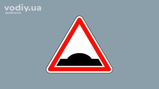 Дорожній знак 1.11 «Пагорб» на сірому фоні, попередження про нерівність дороги або штучну нерівність для обмеження швидкості.