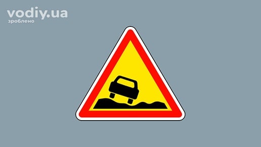 Дорожній знак 1.15 «Небезпечне узбіччя» на жовтому фоні, попередження про підвищене, занижене або зруйноване узбіччя.