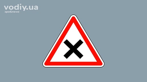 Дорожній знак 1.21 «Перехрещення рівнозначних доріг» на сірому фоні.