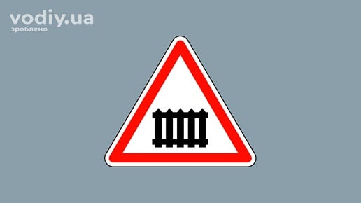 Дорожній знак 1.27 «Залізничний переїзд із шлагбаумом» на сірому фоні.