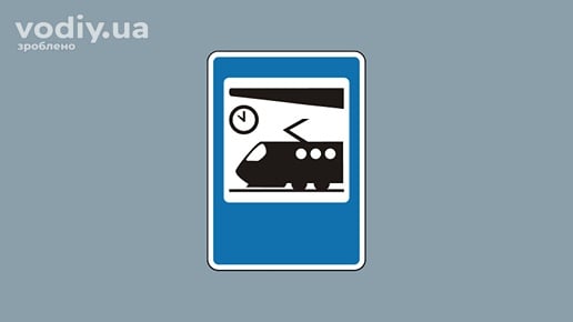 Дорожній знак 5.72 «Залізничний вокзал чи пункт зупинки поїздів» на синьому фоні з піктограмою потяга та годинника.