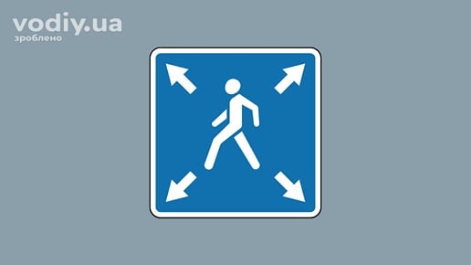 Дорожній знак 5.39 «Діагональний пішохідний перехід» на синьому фоні з білим силуетом пішохода та стрілками по кутах.
