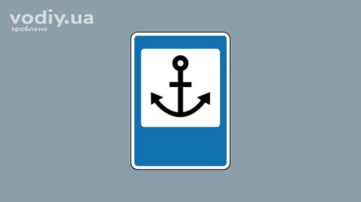 Дорожній знак 5.77 «Морський (річковий) порт чи вокзал» на синьому фоні із зображенням якоря.