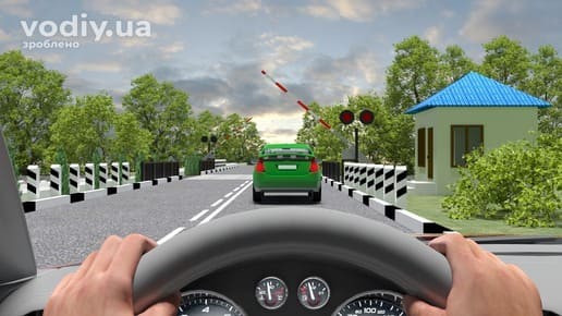 Проїзд залізничного переїзду, коли шлагбаум опускається та миготить червоний сигнал світлофора