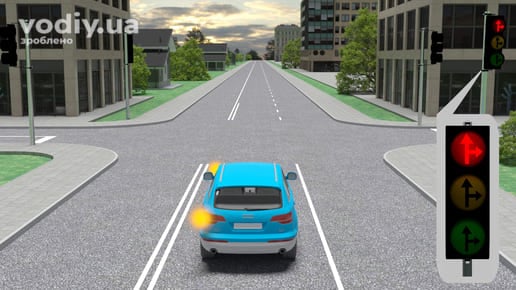 Синій автомобіль перед перехрестям, червоний сигнал світлофора з чорними контурними стрілками прямо та праворуч, увімкнено лівий покажчик повороту.