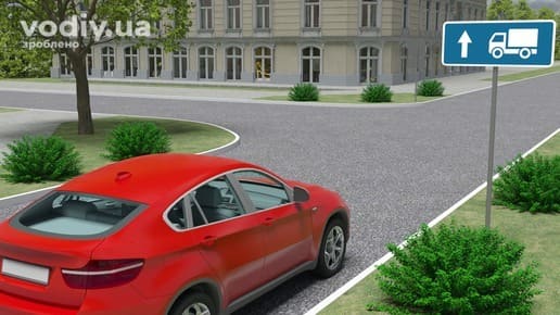 Червоний автомобіль перед перехрестям, дорожній знак 5.31.1 «Напрямок руху для вантажних автомобілів». Напрямки руху на Т-подібному перехресті.