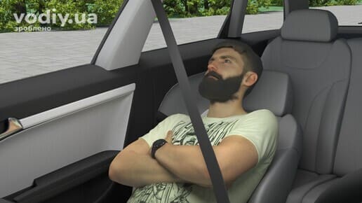 Пасажир у напівлежачому положенні на передньому сидінні автомобіля, пристебнутий ремінь безпеки.