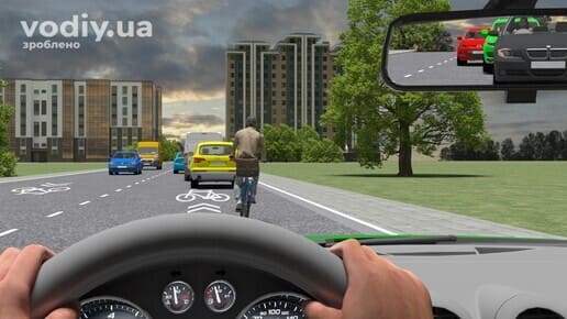 Велосипедист на дорозі попереду автомобіля, затор у місті, вид з дзеркала заднього виду на колону машин.