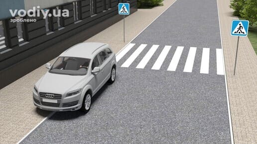 Сірий автомобіль зупинився біля краю проїзної частини безпосередньо перед дорожніми знаками 5.38.1 та 5.38.2 «Пішохідний перехід».