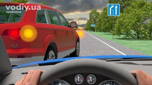Червоний автомобіль попереду з увімкненим правим покажчиком повороту, дорожній знак 5.20.1 «Початок додаткової смуги руху», агресивне водіння.