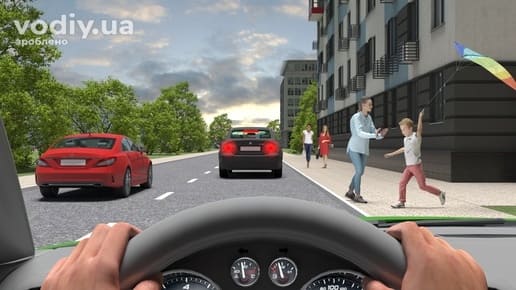 Дитина з повітряним змієм біжить по тротуару в бік проїзної частини, автомобілі на дорозі в населеному пункті, вид з місця водія.