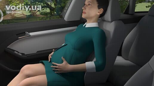 Вагітна жінка на пасажирському сидінні автомобіля, використання ременів безпеки під час вагітності.