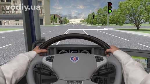 Вид з кабіни вантажівки на регульоване перехрестя, зелений сигнал світлофора, рух вантажного автомобіля по крайній лівій смузі дороги.