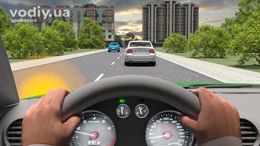 Зелений автомобіль з увімкненим лівим покажчиком повороту, біле авто попереду та синій зустрічний автомобіль на дорозі поза населеним пунктом.