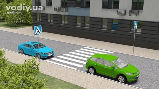 Дорожні знаки 5.38.1, 5.38.2 «Пішохідний перехід», синій та зелений автомобілі зупинилися біля розмітки 1.14.1 «зебра» в межах населеного пункту.