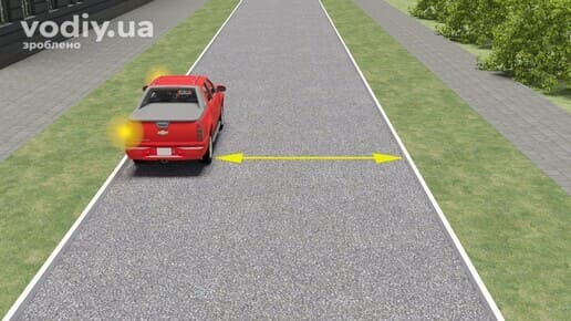 Червоний автомобіль зупинився біля краю дороги, вимірювання відстані від авто до протилежного краю проїзної частини.