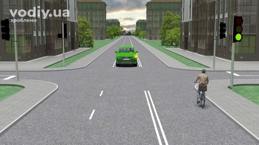 Зелений автомобіль з увімкненим лівим покажчиком повороту та велосипедист на регульованому перехресті, зелений сигнал світлофора.