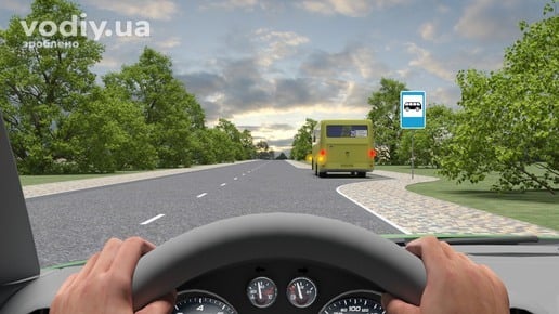 Автобус із увімкненим лівим покажчиком повороту в заїзному кармані, дорожній знак 5.45.1 «Пункт зупинки автобуса» поза населеним пунктом.