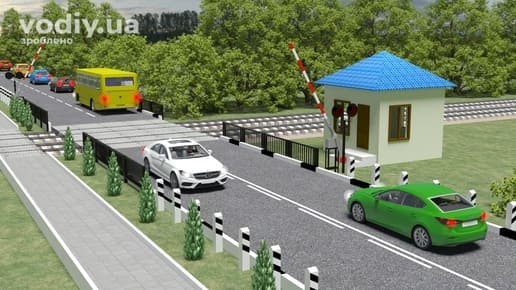 Зелений автомобіль перед залізничним переїздом, затор за переїздом, відкритий шлагбаум та білий автомобіль на коліях.
